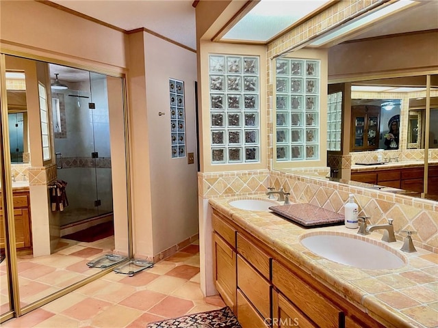 bathroom with tasteful backsplash, vanity, crown molding, and a shower with shower door