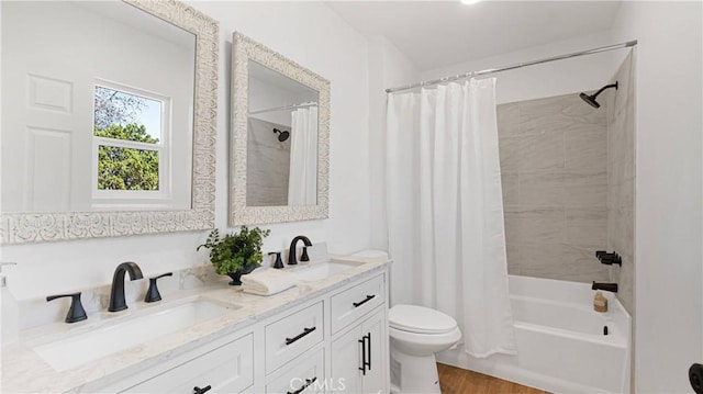 full bathroom featuring wood-type flooring, vanity, shower / tub combo, and toilet