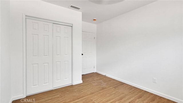 unfurnished bedroom featuring light hardwood / wood-style floors and a closet