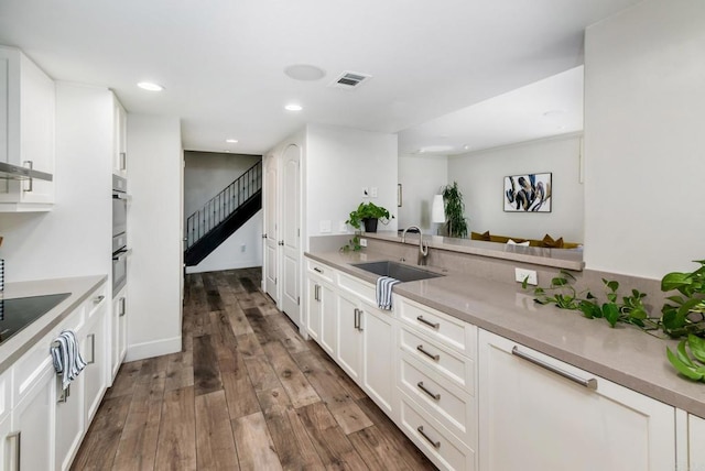 kitchen with sink, white cabinets, and dark hardwood / wood-style flooring