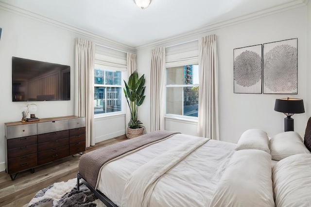 bedroom with crown molding and hardwood / wood-style floors