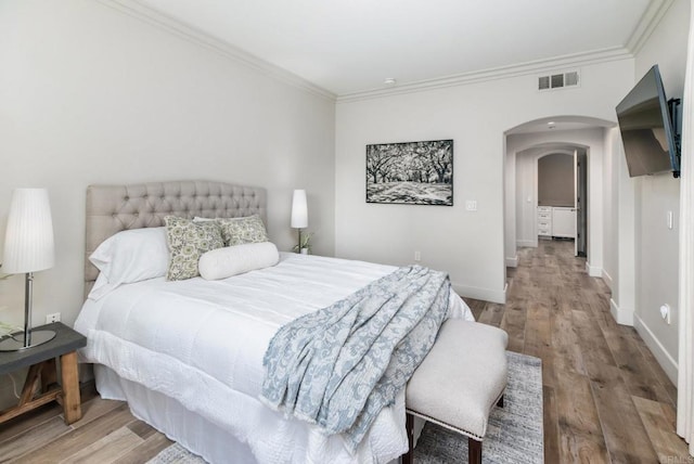 bedroom with ornamental molding and light wood-type flooring