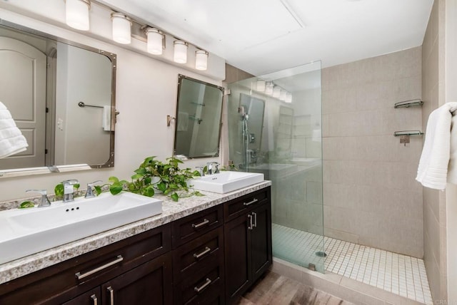 bathroom featuring vanity, hardwood / wood-style floors, and tiled shower