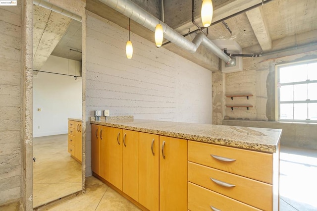 kitchen featuring pendant lighting and light stone counters