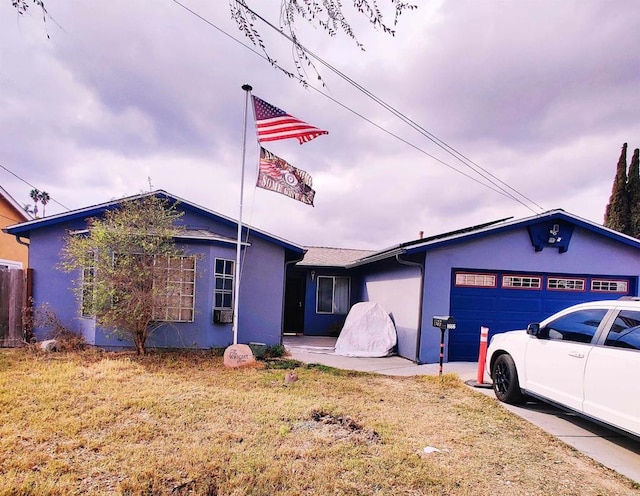 ranch-style house featuring a garage and a front lawn