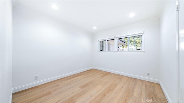 spare room with crown molding and light hardwood / wood-style floors