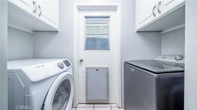 clothes washing area with cabinets, light tile patterned floors, and independent washer and dryer