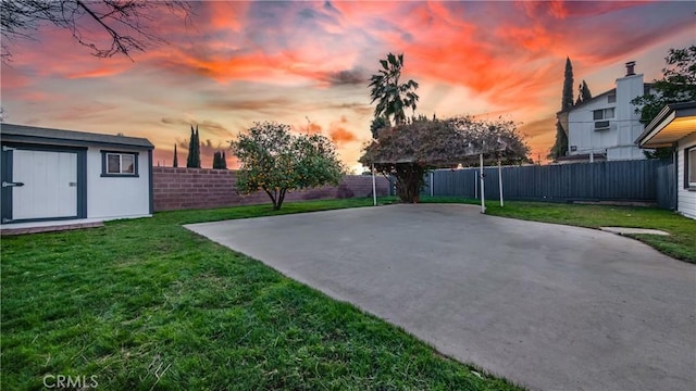 patio terrace at dusk with an outbuilding and a lawn