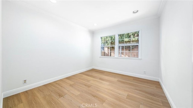 spare room with light hardwood / wood-style flooring and ornamental molding