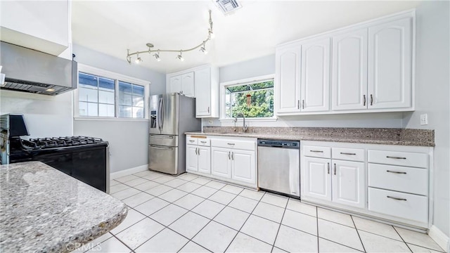 kitchen with white cabinetry, appliances with stainless steel finishes, sink, and light stone counters