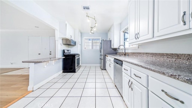 kitchen with white cabinetry, appliances with stainless steel finishes, sink, and light tile patterned flooring