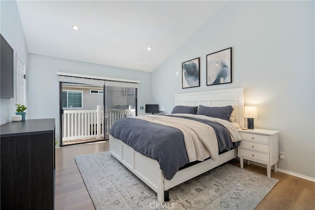 bedroom with lofted ceiling, hardwood / wood-style flooring, and access to outside