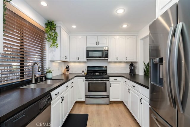 kitchen featuring white cabinetry, sink, decorative backsplash, and stainless steel appliances