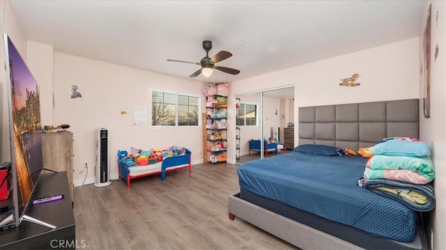 bedroom with wood-type flooring, ceiling fan, and a closet