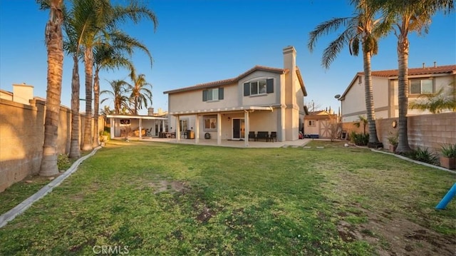 back of property with a patio and a lawn