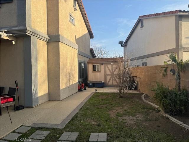 view of yard featuring a storage shed and a patio area