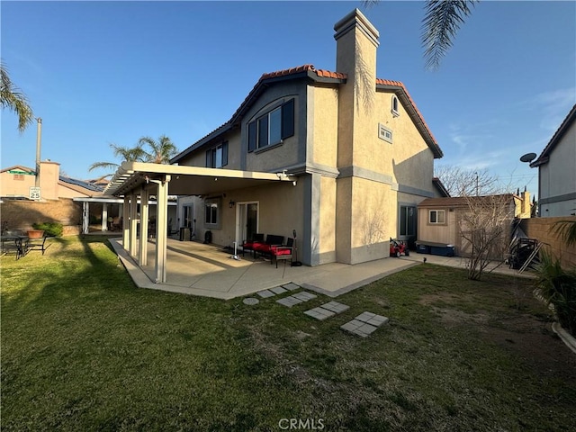 rear view of house with a storage unit, a patio, and a lawn