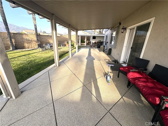 view of patio with fence and a mountain view