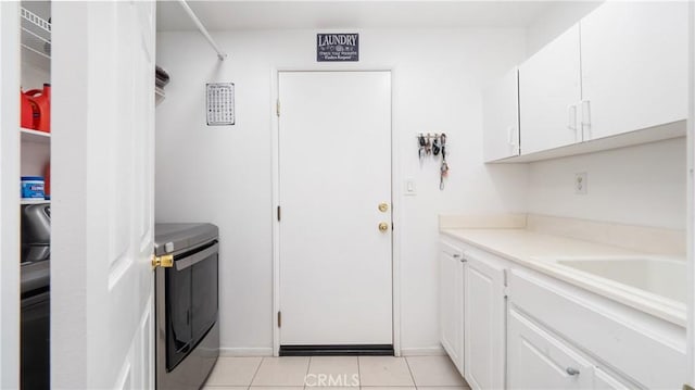 laundry room featuring a sink, cabinet space, washer and dryer, and light tile patterned flooring