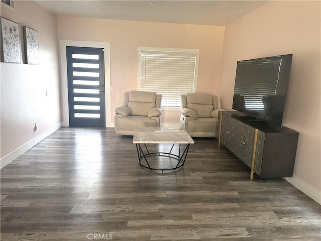 living area with dark wood-type flooring and baseboards