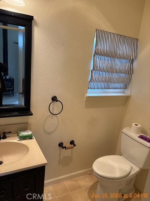 bathroom featuring tile patterned flooring, vanity, and toilet