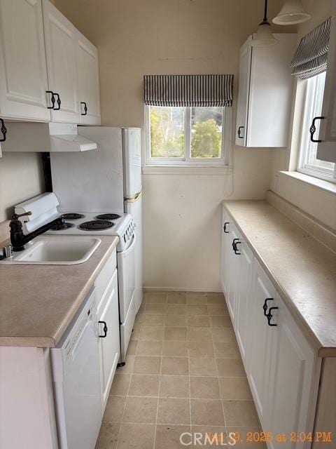 kitchen with pendant lighting, white appliances, plenty of natural light, and white cabinets