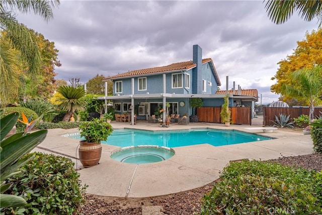 view of swimming pool featuring an in ground hot tub, a diving board, and a patio