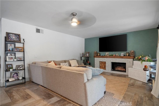 living room with hardwood / wood-style flooring, a fireplace, and ceiling fan