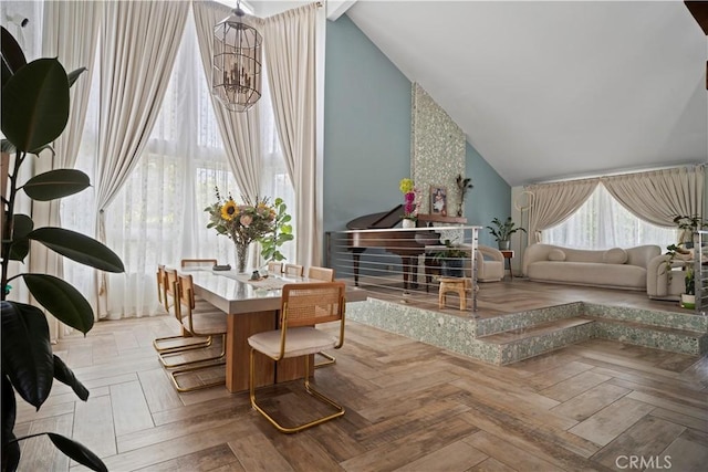 sitting room featuring light parquet flooring, a notable chandelier, and high vaulted ceiling