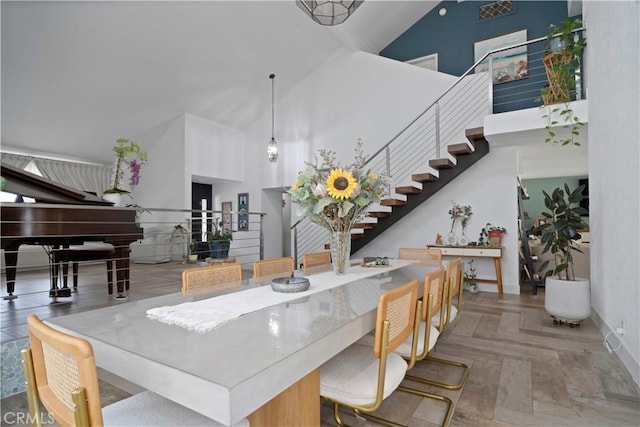 interior space with parquet floors, high vaulted ceiling, and hanging light fixtures