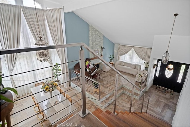 interior space with vaulted ceiling, parquet flooring, and a notable chandelier