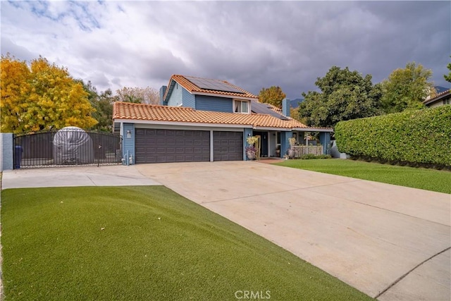 view of front of home with a garage, a front yard, and solar panels