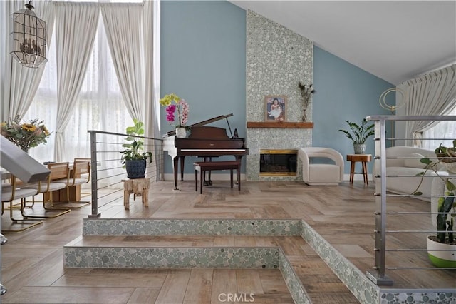 sitting room with a large fireplace, parquet floors, and high vaulted ceiling