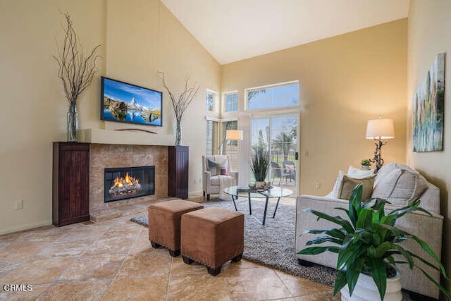 living room with a high ceiling and a tile fireplace