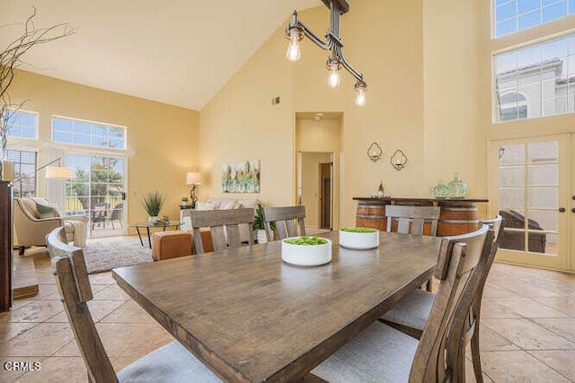 dining area with light tile patterned flooring and high vaulted ceiling