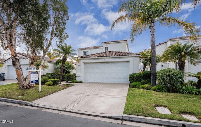 mediterranean / spanish house featuring a garage and a front lawn