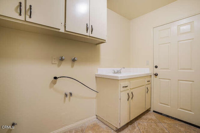 laundry room with cabinet space and a sink