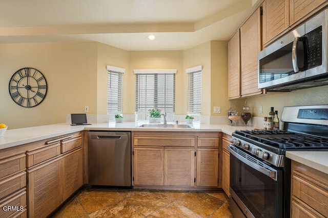 kitchen featuring stainless steel appliances, light countertops, and a sink