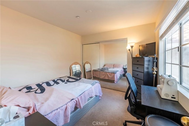 bedroom with light carpet and a closet