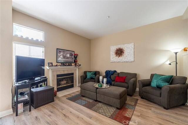 living room with a fireplace, wood finished floors, and baseboards