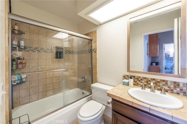 full bath with toilet, shower / bath combination with glass door, decorative backsplash, and vanity