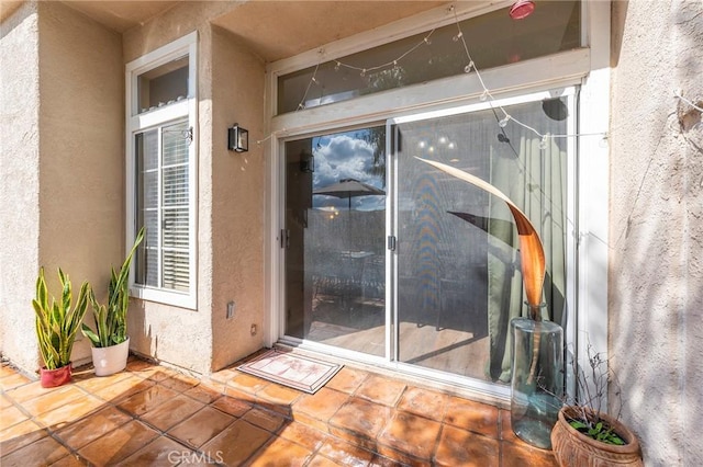 view of exterior entry with a patio area