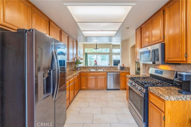 kitchen with sink, light tile patterned floors, stainless steel appliances, tasteful backsplash, and light stone counters