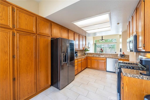 kitchen featuring appliances with stainless steel finishes, sink, backsplash, light tile patterned floors, and light stone counters