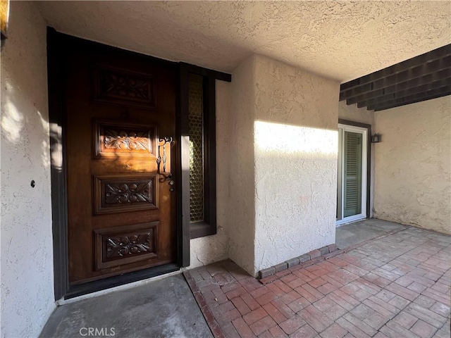 doorway to property featuring stucco siding