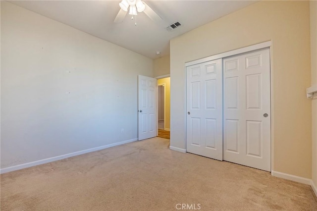 unfurnished bedroom with light carpet, a closet, and ceiling fan