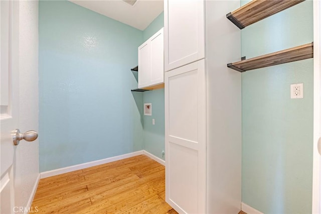 clothes washing area with hookup for a washing machine, cabinets, and light wood-type flooring