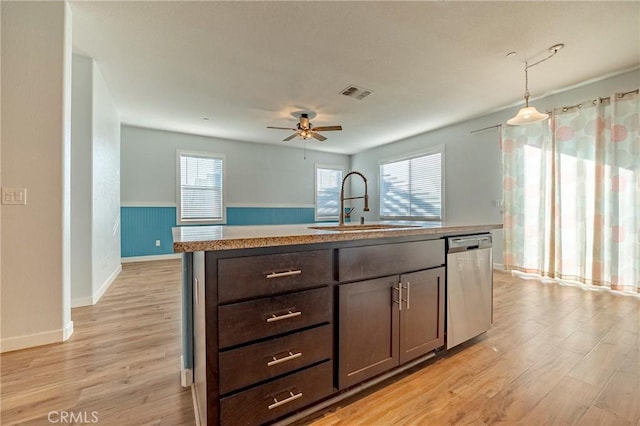 kitchen with sink, a center island with sink, stainless steel dishwasher, plenty of natural light, and pendant lighting