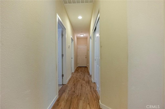 hallway with light hardwood / wood-style floors