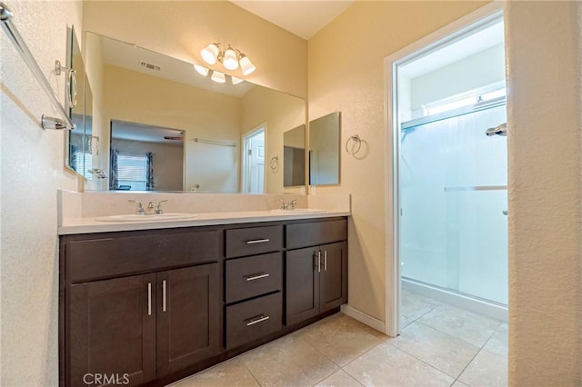 bathroom featuring vanity, a shower with shower door, and tile patterned flooring